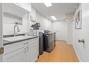 Laundry room featuring washing machine and clothes dryer, cabinet space, light wood finished floors, and baseboards