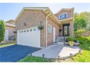View of front of property with driveway, brick siding, and a garage