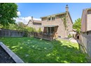 Back of house with a wooden deck, brick siding, and a chimney