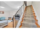 Staircase featuring wood finished floors, a textured ceiling, ornamental molding, and baseboards