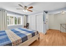 Bedroom with light wood-style floors, a closet, a textured ceiling, ceiling fan, and baseboards