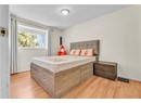 Bedroom with light wood-style flooring, baseboards, and a textured ceiling