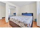 Bedroom with wood finished floors, a closet, and baseboards