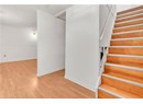 Stairway with wood finished floors, baseboards, and a textured ceiling