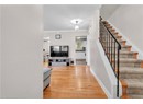 Stairway with wood finished floors, ornamental molding, baseboards, and a textured ceiling