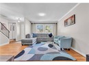 Living area with wood finished floors, stairway, a textured ceiling, baseboards, and crown molding