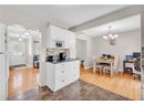 Kitchen with a chandelier, freestanding refrigerator, white cabinetry, dark countertops, and tasteful backsplash