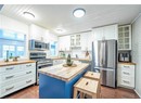 Kitchen with wood counters, dark hardwood / wood-style flooring, stainless steel appliances, a center island, and white cabinetry