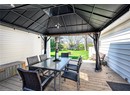 Deck featuring a gazebo, a trampoline, outdoor dining space, and a yard