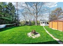 View of yard featuring a storage unit, a trampoline, an outdoor structure, and an outdoor fire pit