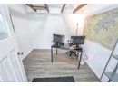 Office area with beam ceiling and dark hardwood / wood-style flooring