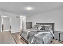 Bedroom with light hardwood / wood-style floors and ensuite bathroom