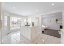 Kitchen with light stone countertops, baseboards, recessed lighting, and white cabinetry