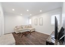 Living area featuring dark wood-type flooring, crown molding, baseboards, and recessed lighting