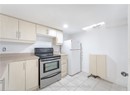 Kitchen with stainless steel electric stove, light brown cabinetry, light tile patterned floors, light countertops, and freestanding refrigerator