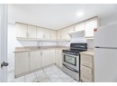 Kitchen with light countertops, a sink, light tile patterned flooring, freestanding refrigerator, and stainless steel range with electric stovetop