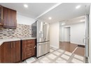 Kitchen featuring backsplash, baseboards, and stainless steel fridge