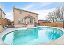 Back of property featuring brick siding, a fenced in pool, and a fenced backyard