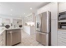 Kitchen with light tile patterned flooring, glass insert cabinets, white cabinetry, appliances with stainless steel finishes, and recessed lighting