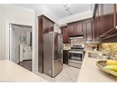 Kitchen with light countertops, crown molding, stainless steel appliances, under cabinet range hood, and a sink