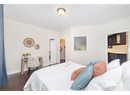 Bedroom featuring baseboards, dark wood-style flooring, and ensuite bathroom