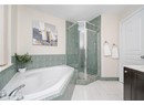 Bathroom featuring a bath, a stall shower, tile patterned floors, and vanity