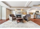 Living room featuring baseboards, dark wood finished floors, beamed ceiling, visible vents, and a tiled fireplace