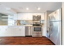Kitchen with light countertops, dark wood-style flooring, stainless steel appliances, and white cabinetry