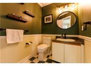 Half bathroom with vanity, tile patterned floors, and crown molding