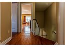Hallway with an upstairs landing and wood-type flooring