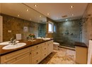 Full bath with a shower stall, double vanity, tile walls, and recessed lighting