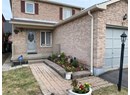 Doorway to property featuring a garage, covered porch, and brick siding