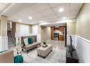 Living room with a drop ceiling, recessed lighting, stairs, a wainscoted wall, and light tile patterned floors