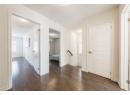 Hallway featuring a textured ceiling, dark wood finished floors, and healthy amount of natural light