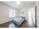 Bedroom with multiple windows, a textured ceiling, and dark wood finished floors