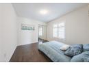 Bedroom with dark wood-type flooring, a textured ceiling, and a closet