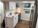 Kitchen featuring appliances with stainless steel finishes, wall chimney range hood, dark wood finished floors, and white cabinetry