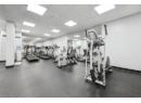 Exercise room with a drop ceiling and baseboards