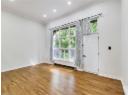 Empty room with crown molding, wood-type flooring, a baseboard radiator, and recessed lighting
