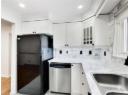 Kitchen with freestanding refrigerator, white cabinetry, glass insert cabinets, dishwasher, and recessed lighting