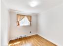 Empty room featuring a baseboard radiator, light wood finished floors, and ornamental molding