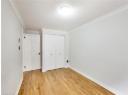 Unfurnished bedroom with light wood-style flooring, a closet, and ornamental molding