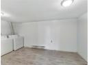 Laundry room featuring a baseboard heating unit, washer and dryer, and light wood-type flooring