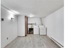 Laundry room with a baseboard radiator, light wood-type flooring, and washer and dryer