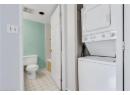 Laundry area featuring light tile patterned flooring and estacked washer and dryer