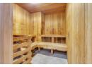 Relaxing sauna featuring wood ceiling, tile patterned flooring, and wooden walls