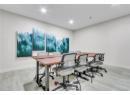 Office with light wood-type flooring and recessed lighting