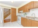 Kitchen featuring white gas range, light tile patterned floors, tasteful backsplash, freestanding refrigerator, and under cabinet range hood