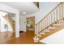Foyer entrance with stairs, wood finished floors, and a textured ceiling