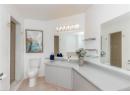 Bathroom featuring light tile patterned floors, vanity, and a tile shower